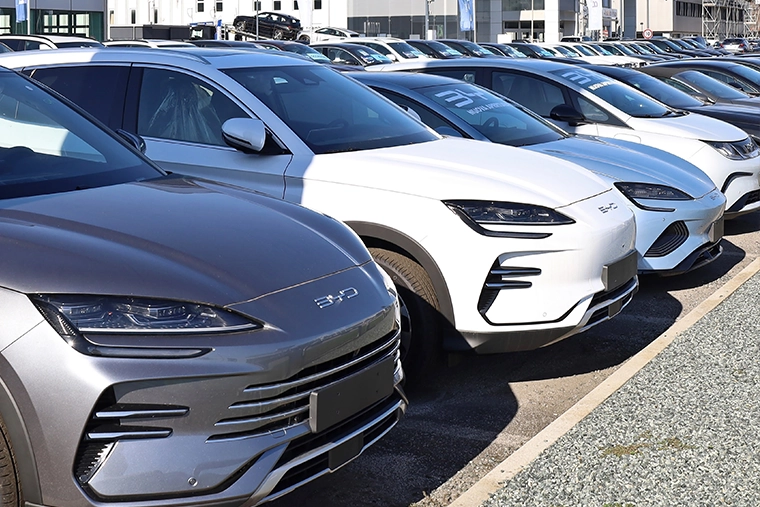 Line-up of BYD electric SUVs and saloons parked outside a dealership, highlighting popular Chinese electric car brands and modern EV design.