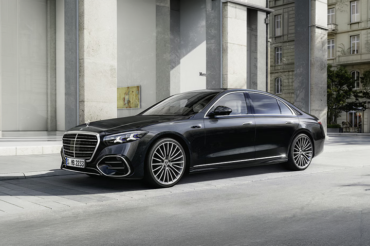 Black Mercedes-Benz S-Class luxury saloon parked outside a modern city building.