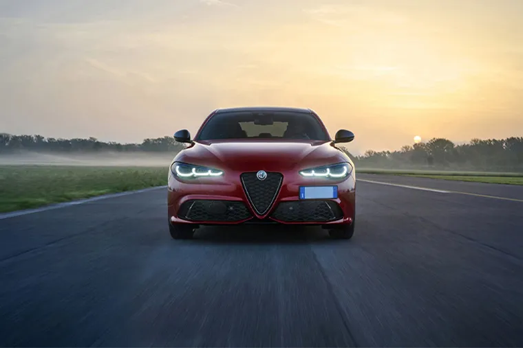 Red Alfa Romeo Giulia front view driving at sunset