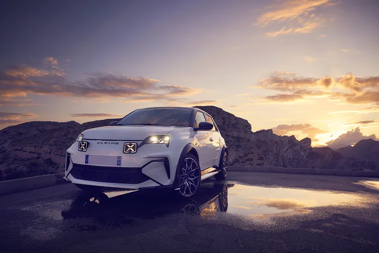 White Alpine A290 electric hot hatch parked at sunset in the mountains