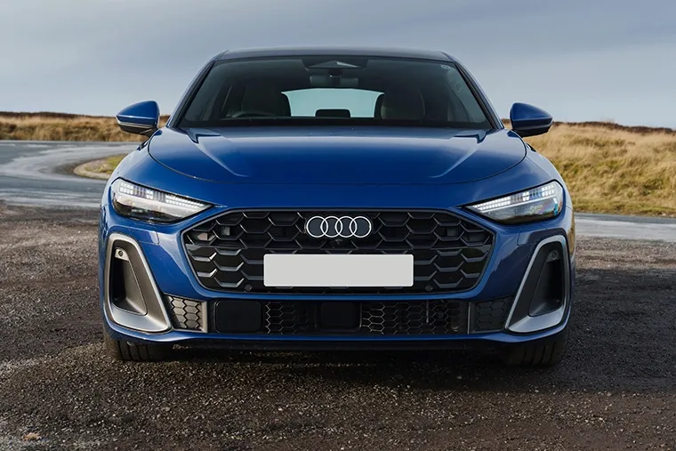 Audi A5 Sportback in metallic blue with honeycomb grille and Matrix LED headlights, photographed on country road.