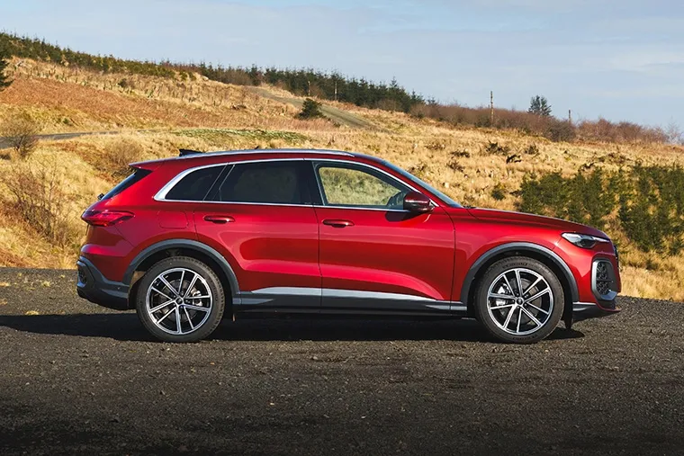 Audi Q4 e-tron electric SUV parked at sunset, showcasing sleek rear styling.