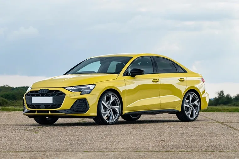 Audi Q3 SUV parked in rural landscape, highlighting compact crossover design with sporty alloy wheels and high stance.