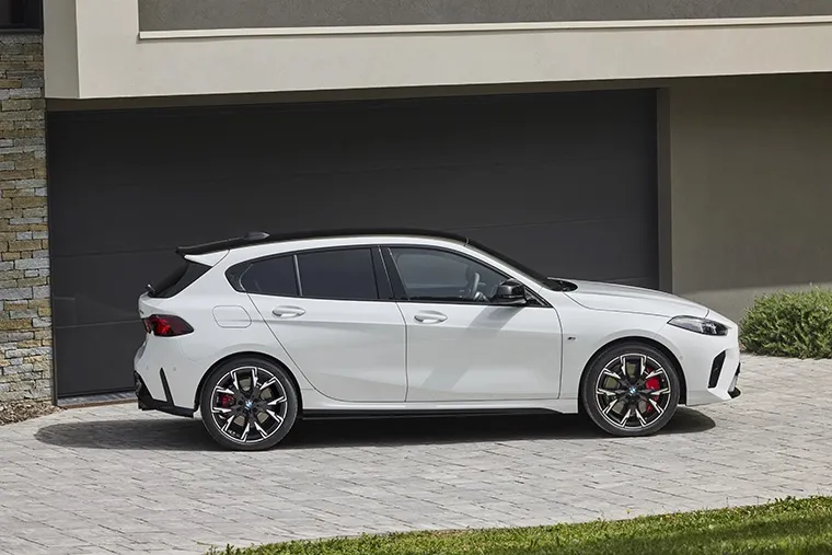 BMW 1 Series M Sport hatchback parked in a residential driveway, finished in grey with gloss black trim and M alloy wheels