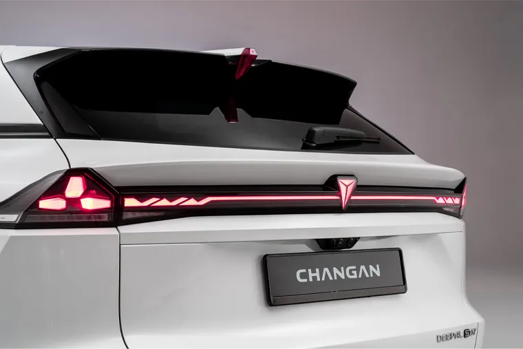 Close-up rear view of a white Changan vehicle, showcasing a full-width red LED taillight bar, the Changan badge, and a glossy black rear window.