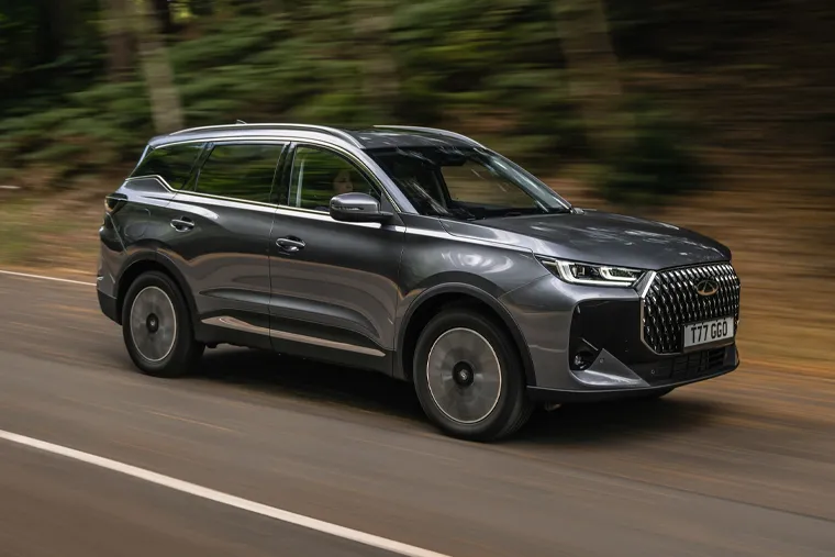 Chery SUV driving on a forest road, showcasing its sleek grey exterior, aerodynamic design and modern front grille for a premium family SUV look.