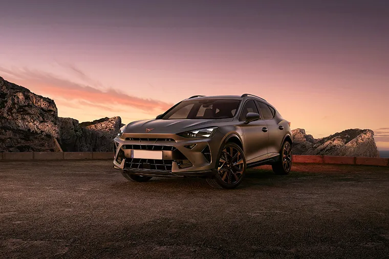 Cupra Formentor SUV parked against a dramatic coastal backdrop at sunset, showcasing its sporty styling and bold presence.