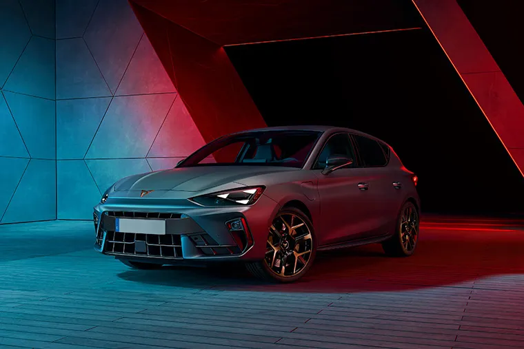 Born electric hatchback in a dramatic studio setting with neon red and blue lighting