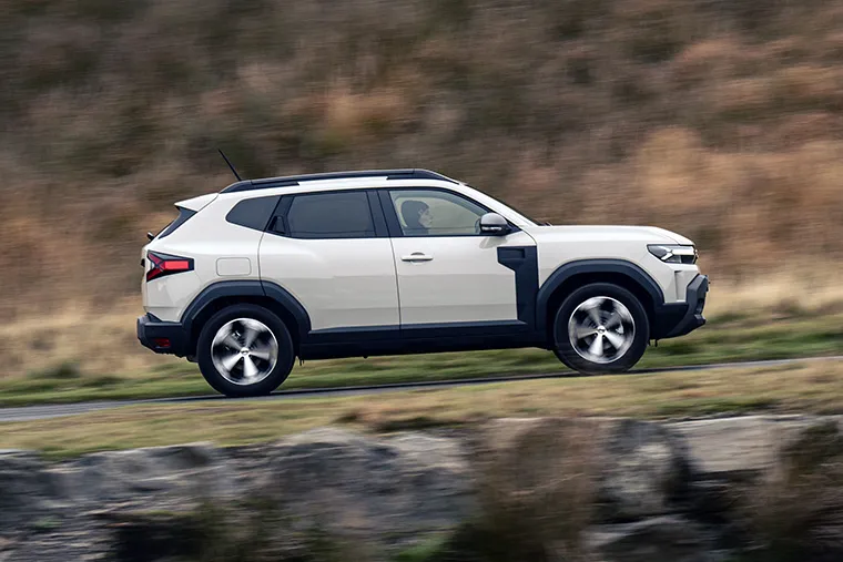 Dacia Duster SUV driving off-road next to a river in countryside