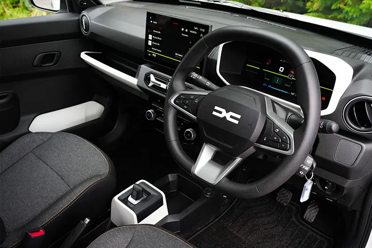 Modern Dacia car interior with digital dashboard, multifunction steering wheel, and touchscreen infotainment.