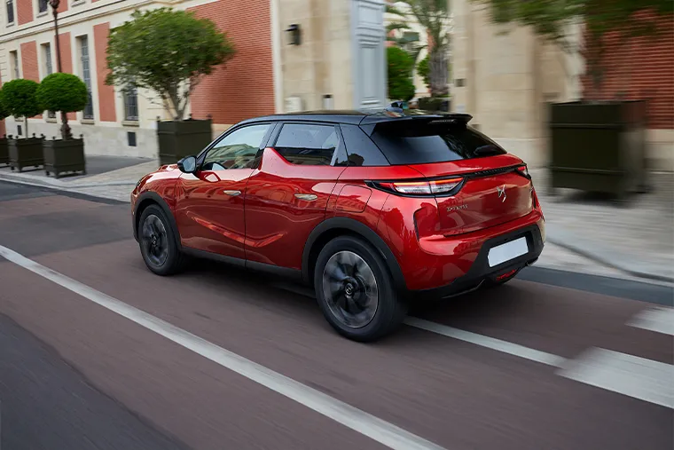Red DS 3 compact SUV rear view driving in the city