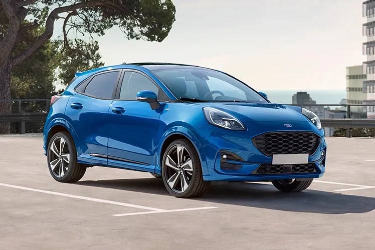 Blue Ford outside on a gravel path during a bright sunny day