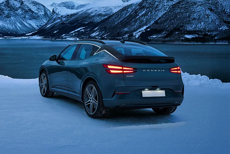 Genesis GV60 electric SUV rear view parked in snowy landscape