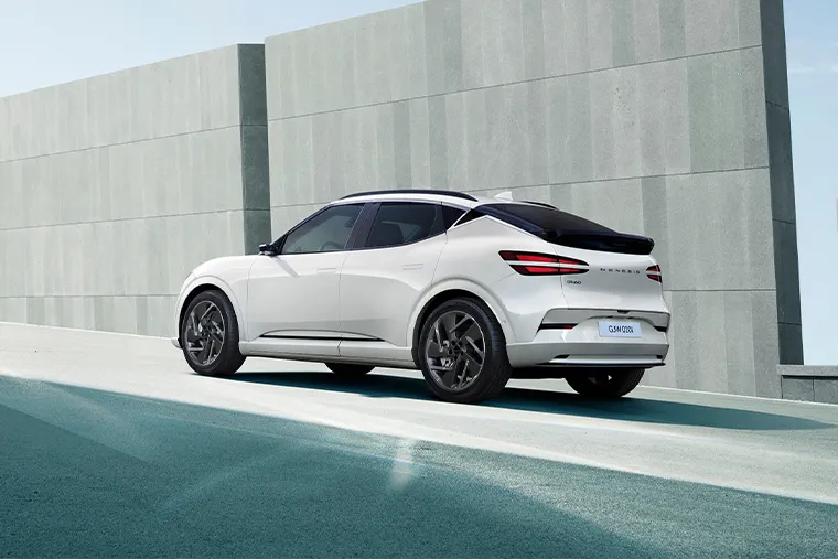 White Genesis GV60 electric SUV rear side view