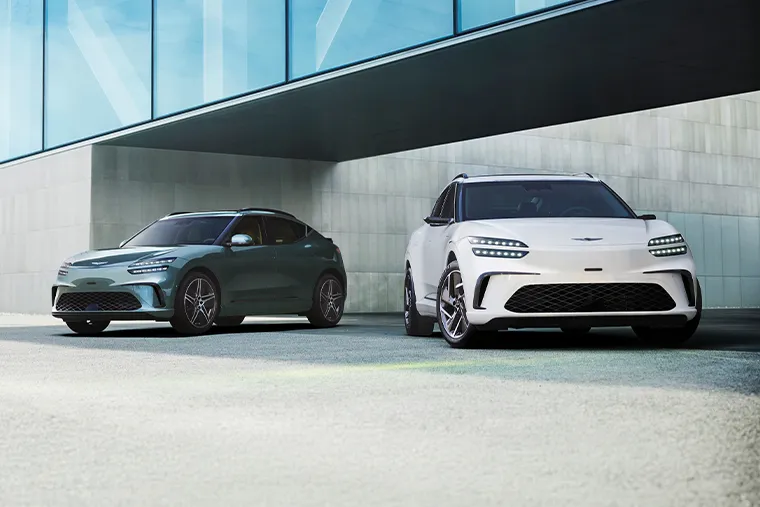 Genesis GV60 electric SUVs in green and white parked side by side