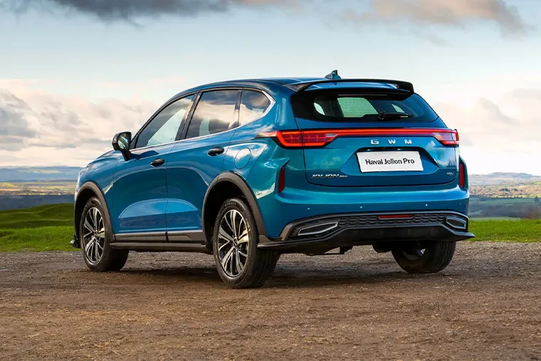 Rear view of blue Haval Jolion Pro SUV parked outdoors with panoramic countryside backdrop