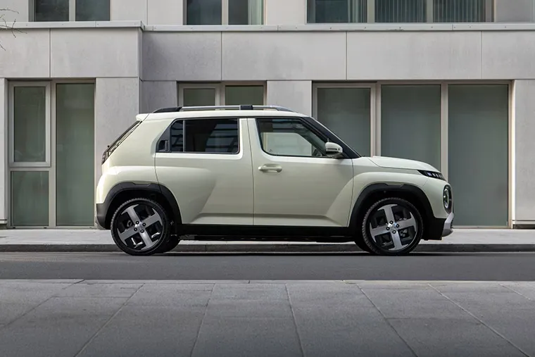 Side view of a compact electric Hyundai SUV parked on an urban street.