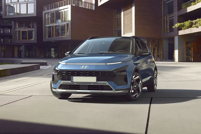 Front view of a blue Hyundai SUV parked in a modern urban courtyard surrounded by contemporary architecture