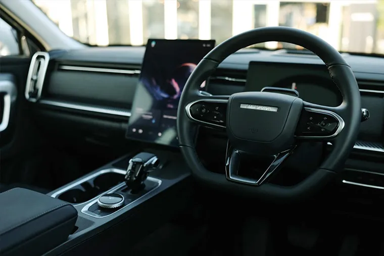 Interior of a Jaecoo SUV featuring digital touchscreen, modern steering wheel, and premium centre console.