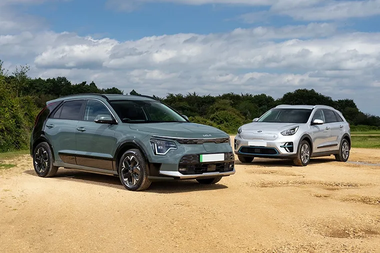 Front view of two Kia Niro electric SUVs parked on a gravel path.