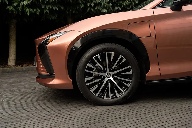 Close-up of a Lexus front wheel and arch with stylish black and silver alloy design, set against a copper paint finish.