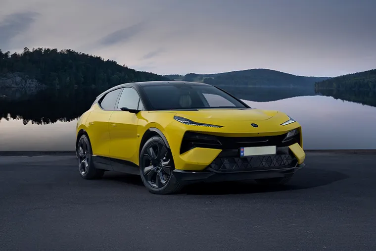 Yellow Lotus Eletre electric SUV parked by a lake with mountain backdrop, front angle view