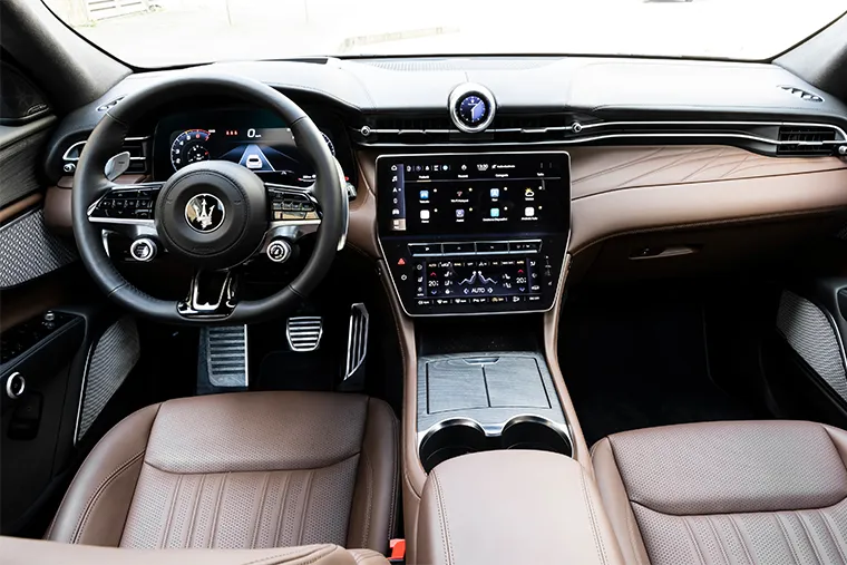 Maserati Grecale luxury SUV interior with brown leather seats, digital cockpit, and touchscreen infotainment system