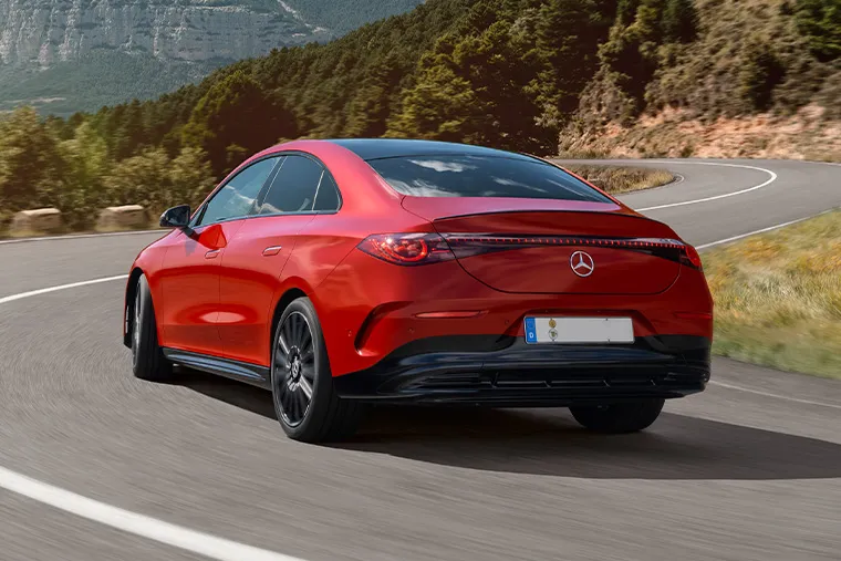 Rear view of red Mercedes-Benz EQE saloon driving on a winding mountain road