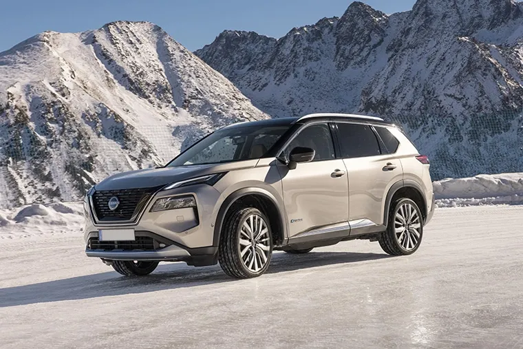 Nissan X-Trail e-POWER SUV driving on snow with mountain backdrop