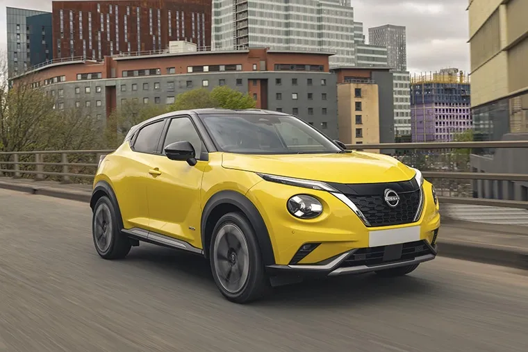 Bold yellow Nissan Juke Hybrid driving through city streets