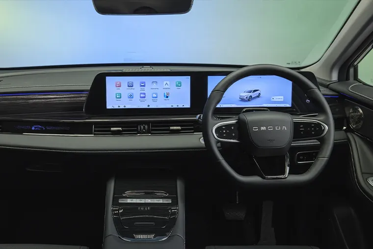 Modern electric car interior featuring a dual-screen digital dashboard and leather steering wheel with backlit controls.