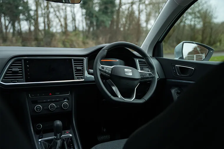 Interior view of a SEAT vehicle featuring the steering wheel and infotainment console.