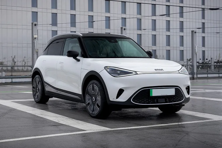 Smart #1 electric SUV in white parked on a wet rooftop with a modern glass building in the background