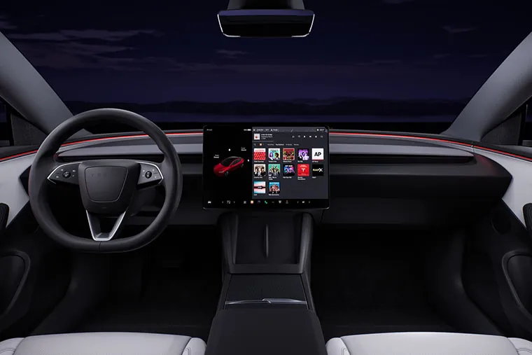 Minimalist interior of a Tesla featuring a sleek steering wheel, large central touchscreen display, and ambient red lighting along the dashboard.