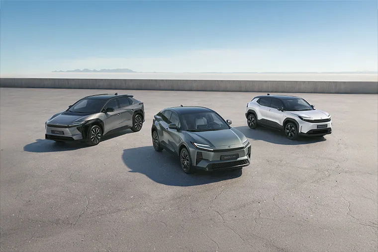 Line-up of Toyota electric and hybrid SUVs including the bZ4X, C-HR, and Urban Cruiser on a wide concrete backdrop.