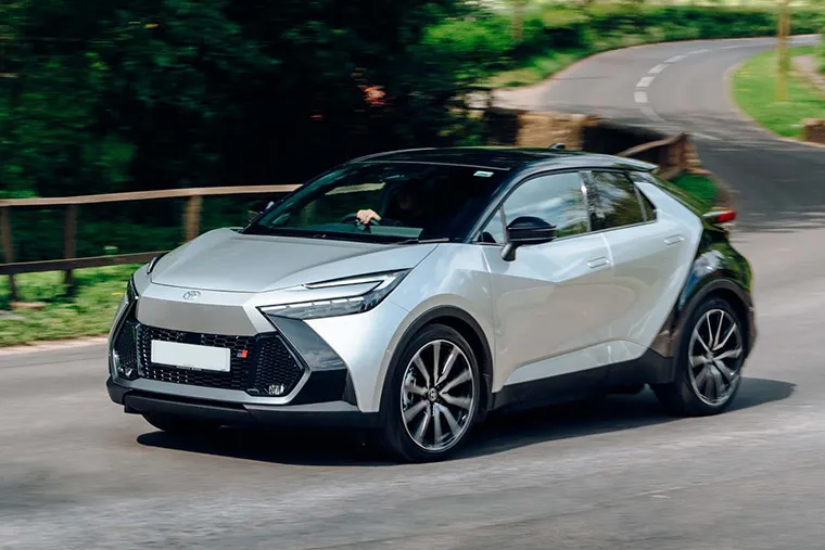 Silver Toyota C-HR GR Sport driving on a country road.