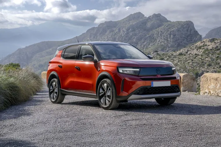 Vauxhall Mokka Electric SUV parked on a scenic mountain road with rocky hills in the background.